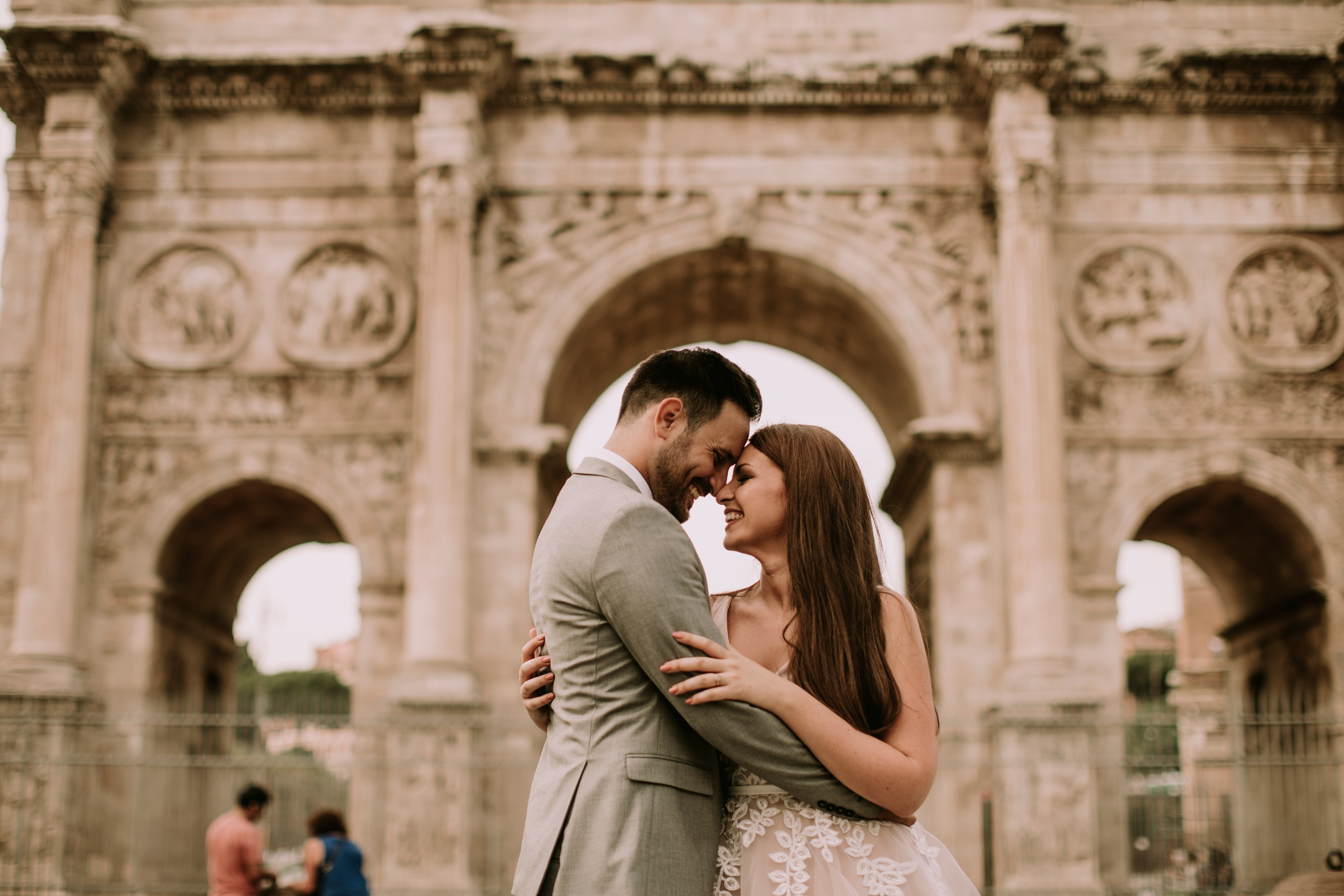 Couple embracing in front of Arch